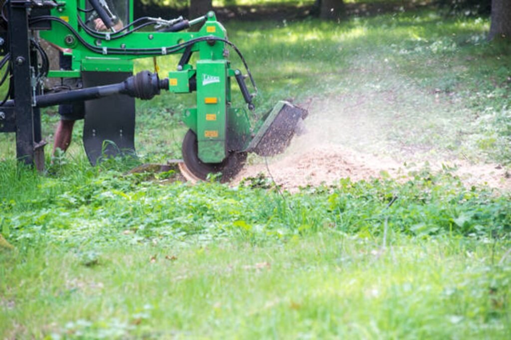 Professional stump grinding machine removing a tree stump below ground level during stump grinding and removal service in St. Louis, MO.